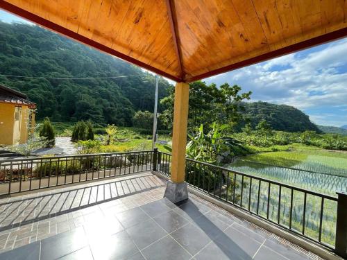 a balcony with a view of a river and mountains at Sky Bay Lodge in Ha Giang