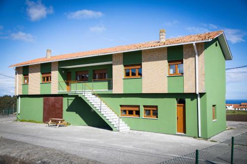 a green building with stairs on the side of it at Playa del Silencio 1 in Castañeras