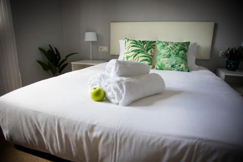a bedroom with a white bed with towels on it at Playa del Silencio 1 in Castañeras