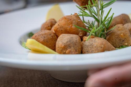 a plate of food with meatballs with a plant on it at Agriturismo Cà Gianin in Vervio