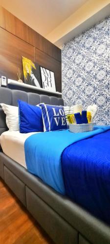a large bed with blue pillows in a bedroom at Air Residences-Stylish&Comfort Stay High flat with balcony in Manila