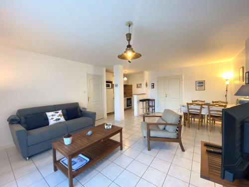 un salon avec un canapé bleu et une table dans l'établissement Appartement face à la plage principale du Coz Pors à Trégastel - Réf 612, à Trégastel