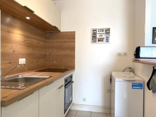 une petite cuisine avec un évier et un réfrigérateur dans l'établissement Appartement face à la plage principale du Coz Pors à Trégastel - Réf 612, à Trégastel