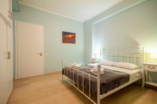 a bedroom with a bed in a room with blue walls at MGI Apartments in Ýpsos