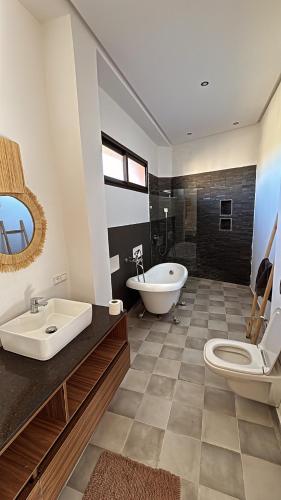 a bathroom with a tub and a toilet and a sink at Villa Mattia piscine chauffée sans vis à vis in Marrakech
