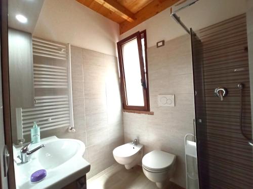 a bathroom with a sink and a toilet and a window at Agriturismo La tana della volpe in Alberese