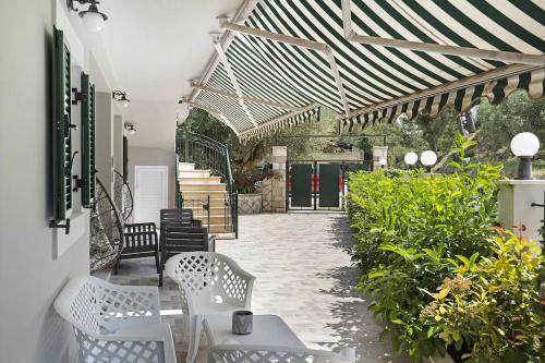 a patio with two white benches and plants at Monte Verde apartments in Lixouri