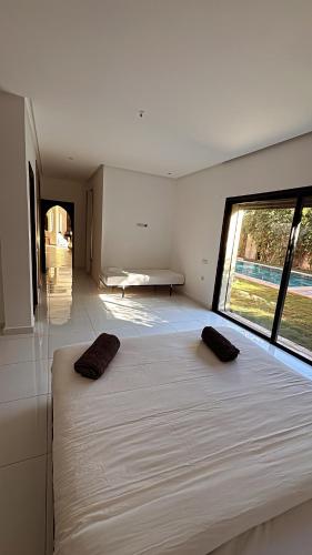 a large bed in a room with a large window at Villa Mattia piscine chauffée sans vis à vis in Marrakech
