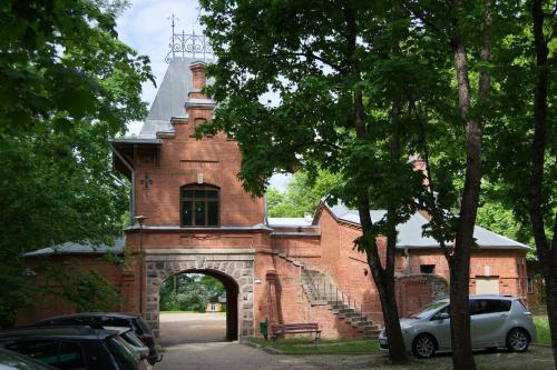 a red brick building with an arch entrance at Pokoje Gościnne Białowieskiego Parku Narodowego, Białowieża in Białowieża