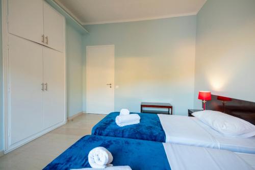 a bedroom with two beds with towels on them at MGI Apartments in Ýpsos