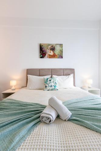 a bedroom with a bed with towels on it at Santorini Villatzio Suites in Mesaria