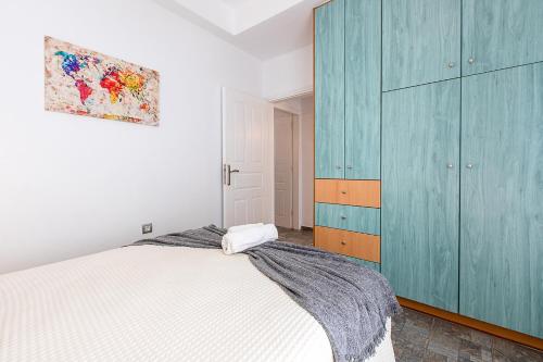 a bedroom with a bed and a blue cabinet at Santorini Villatzio Suites in Mesaria
