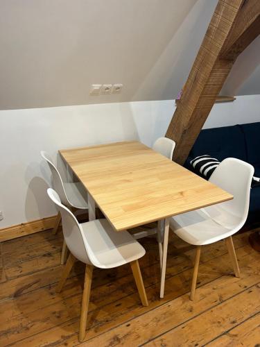 - une table en bois avec des chaises blanches dans l'établissement Appartement Vieux Lille à 300m de Grand Place, à Lille