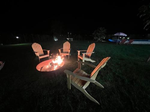 a group of chairs around a fire pit at night at El Patio in San Vito Rimini
