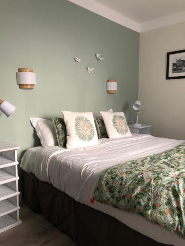 a bedroom with a large bed with pillows at Hotel Les Embruns in Le Touquet-Paris-Plage