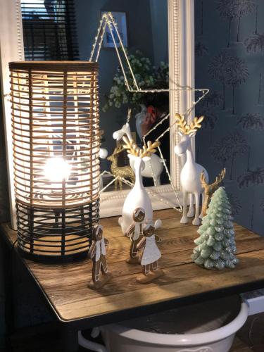 a table with christmas decorations and a light on it at Hotel Les Embruns in Le Touquet-Paris-Plage