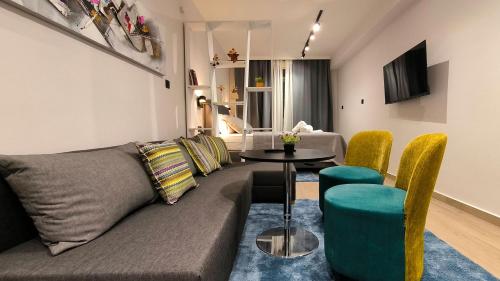 a living room with a couch and a table and chairs at Dk Luxury Studio Xanthi in Xanthi