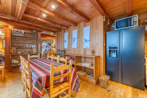 Il comprend une cuisine avec un réfrigérateur en acier inoxydable et des murs en bois. dans l'établissement Chalet Belledonne, à Villard-Reculas