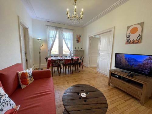 un salon avec un canapé rouge et une table dans l'établissement Le Kablé - Proche Palais de la Musique et des Congrès - Lycée Kléber, à Strasbourg