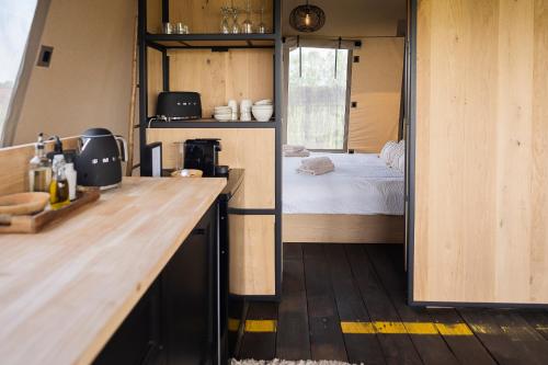 a small kitchen with a bed in a tiny house at Crossover lodge de la vallée in Durbuy