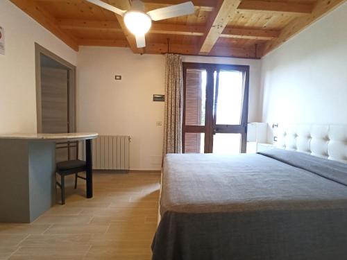 a bedroom with a bed and a table and a window at Agriturismo La tana della volpe in Alberese