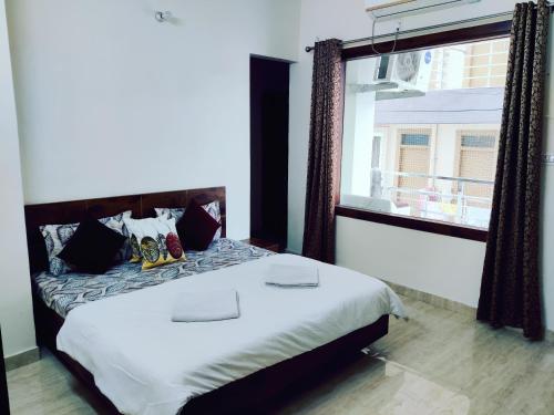 a bedroom with a large bed and a window at Heaven Vibes Stays in Rishīkesh