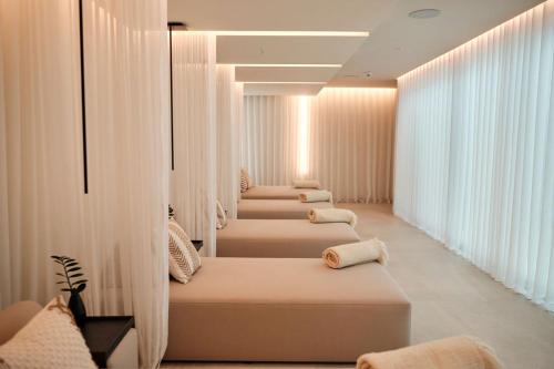a row of beds in a room with windows at RIVA - Das Hotel am Bodensee in Konstanz