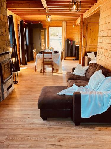 a living room with couches and a table in a room at Chalet cosy Francorchamps in Stavelot