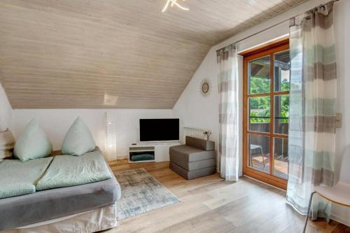 a living room with a couch and a tv at Wohnung Elli in Kumhausen