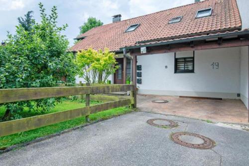 a house with a fence and a driveway at Wohnung Elli in Kumhausen