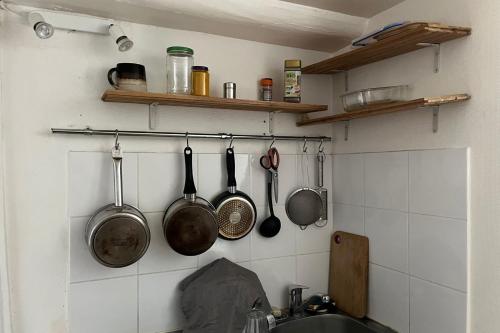 une cuisine avec des casseroles et des poêles accrochées au mur dans l'établissement Beautiful T2 near the Palais Garnier, à Paris