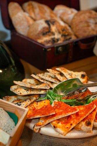 a plate of pizza and bread on a table at Club del Sole Tenuta Primero Grado Family Collection in Grado