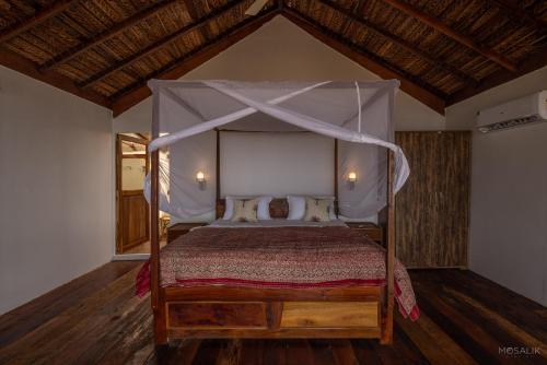 a bedroom with a bed with a canopy at Ravi Yoga Retreat in Polem