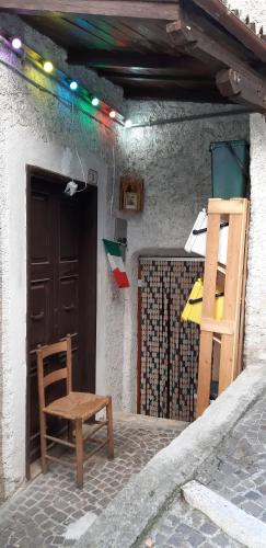 a wooden chair sitting outside of a building with a door at Holiday Rome Hub Brigands' Fortress in Rocca Canterano in Canterano
