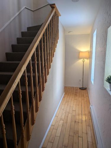 a hallway with stairs and a floor lamp at Au Saut Du Lit in Magog-Orford