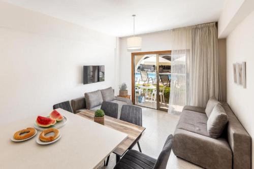a living room with a table and a couch at Stephanos Garden Apartments in Polis Chrysochous