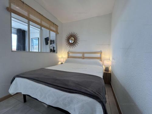 una camera da letto con un letto con uno specchio sul muro di NP060-B08 Appartement 2 pièces 1 chambre, Narbonne Plage a Narbonne-Plage