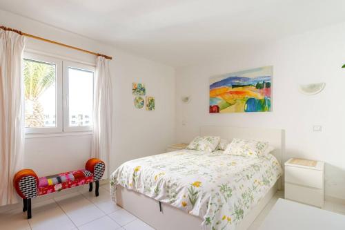 a white bedroom with a bed and a window at Coqueto apart en Las Coronas in Costa Teguise