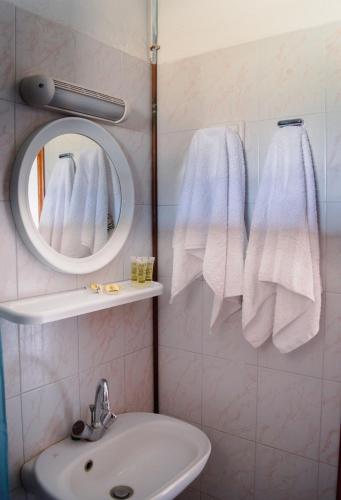 a bathroom with a sink and a mirror and towels at Moonlight Kastraki beach house in Kastraki Naxou