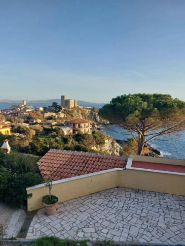 a building with a patio with a view of the water at La mia Casa a Talamone in Talamone