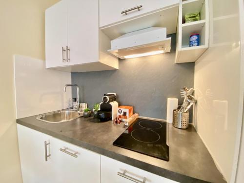 une petite cuisine avec des armoires blanches et un évier dans l'établissement Palais Royal Croisette GIA5407, à Cannes