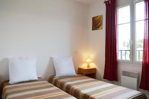 deux lits assis dans une pièce avec une fenêtre dans l'établissement NP110-004 Maison 4 pièces Mezzanine, Narbonne Plage, à Narbonne-Plage