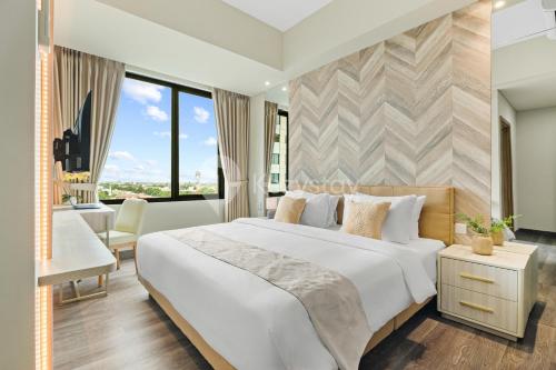 ein Schlafzimmer mit einem großen weißen Bett und einem Schreibtisch in der Unterkunft Amica by Kozystay - Tanjung Barat in Jakarta