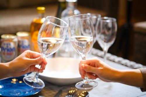 three people holding up wine glasses on a table at MIRATIO Sirius in Onna