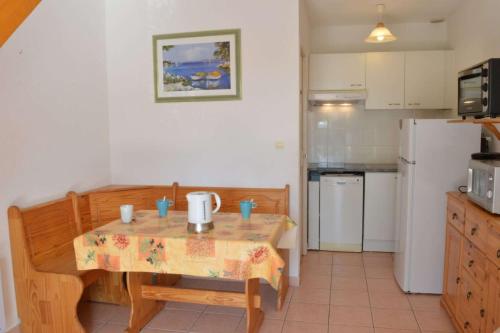 une petite cuisine avec une table et un réfrigérateur dans l'établissement NP150-072 Pavillon 3 pièces, Narbonne Plage, à Narbonne-Plage