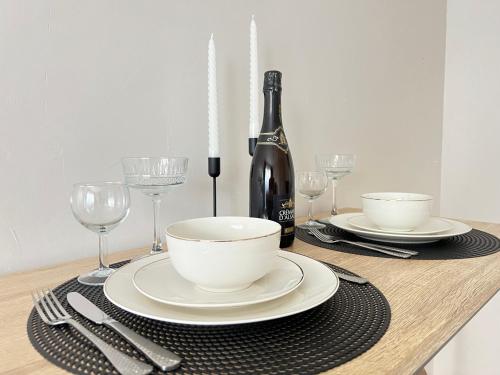 - une table avec une bouteille de vin, des assiettes et des verres dans l'établissement Porte Du Soleil - Cosy Studio Centre, à Strasbourg