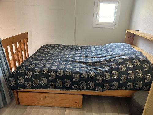 - un lit avec une couette bleue dans l'établissement NP160-441 Pavillon 2 pièces mezzanine, Narbonne Plage, à Narbonne-Plage