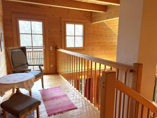 a room with a staircase with a chair and a table at Holiday Home Haus Fries by Interhome in Unterbergern