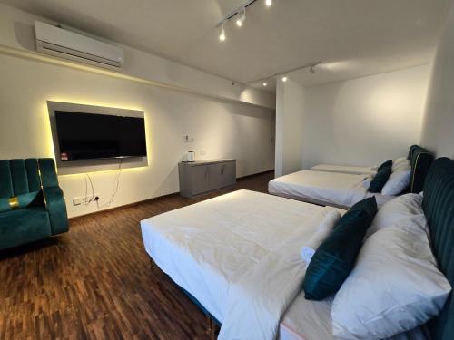 a bedroom with two beds and a flat screen tv at K Avenue Kota Kinabalu by Merveille - Sabah in Donggongon