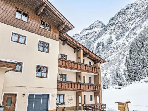 a building in front of a snow covered mountain at Apartment Daheim – Edelweiß by Interhome in Plangeross
